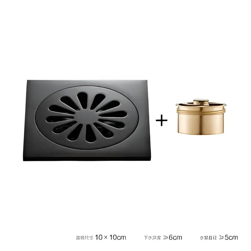 Black brass square floor drain with embossed floral sunburst pattern and gold cylindrical overflow cup for shower room by decorbites