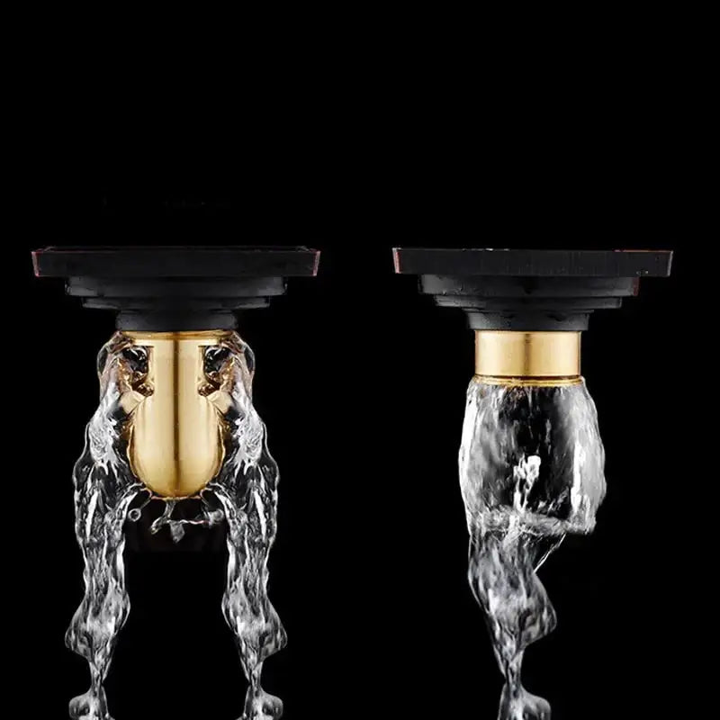Gold-toned faucet with black plastic base and flowing water design paired with decorbites brass square floor drain for shower room