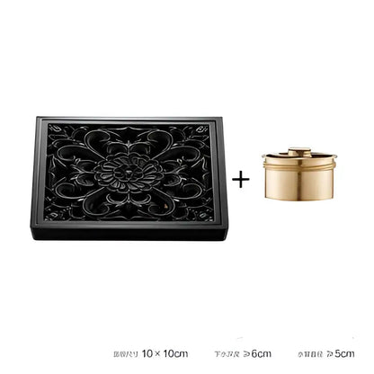 Black lacquered wooden box with floral carvings and golden container beside decorbites brass square floor drain for shower room