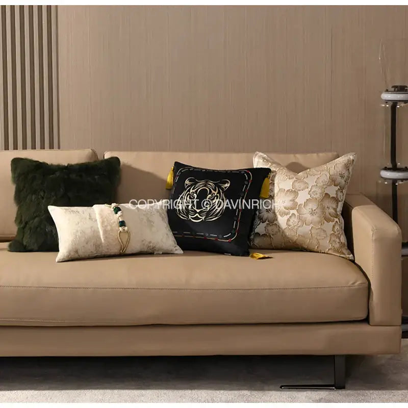 Beige leather sofa with four decorbites embossed floral cushion covers in champagne gold for living room decor
