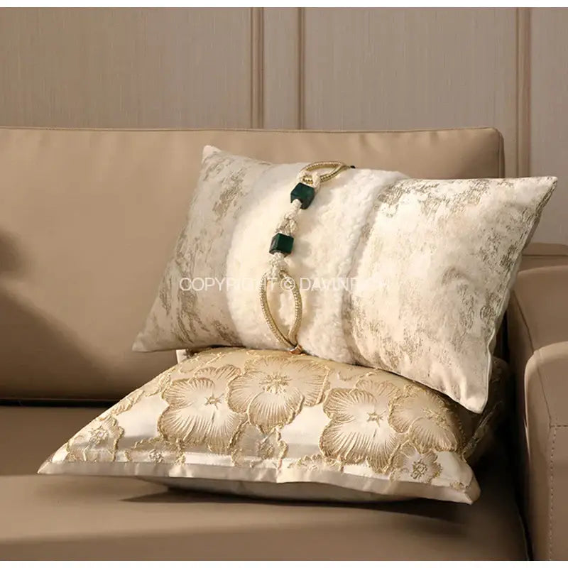 Cream-colored satin cushion cover with gold embossed floral embroidery and green beaded tassel for living room decorbites embossed floral decor