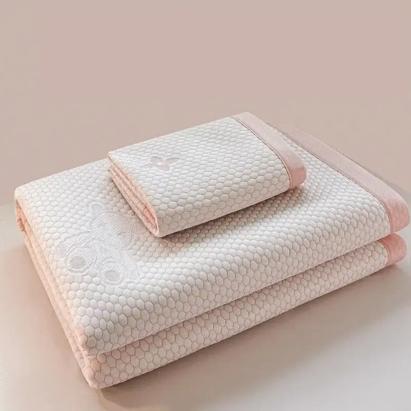 Set of two folded white and pink embroidered floral cooling feel mats with honeycomb pattern mat set for bedroom use
