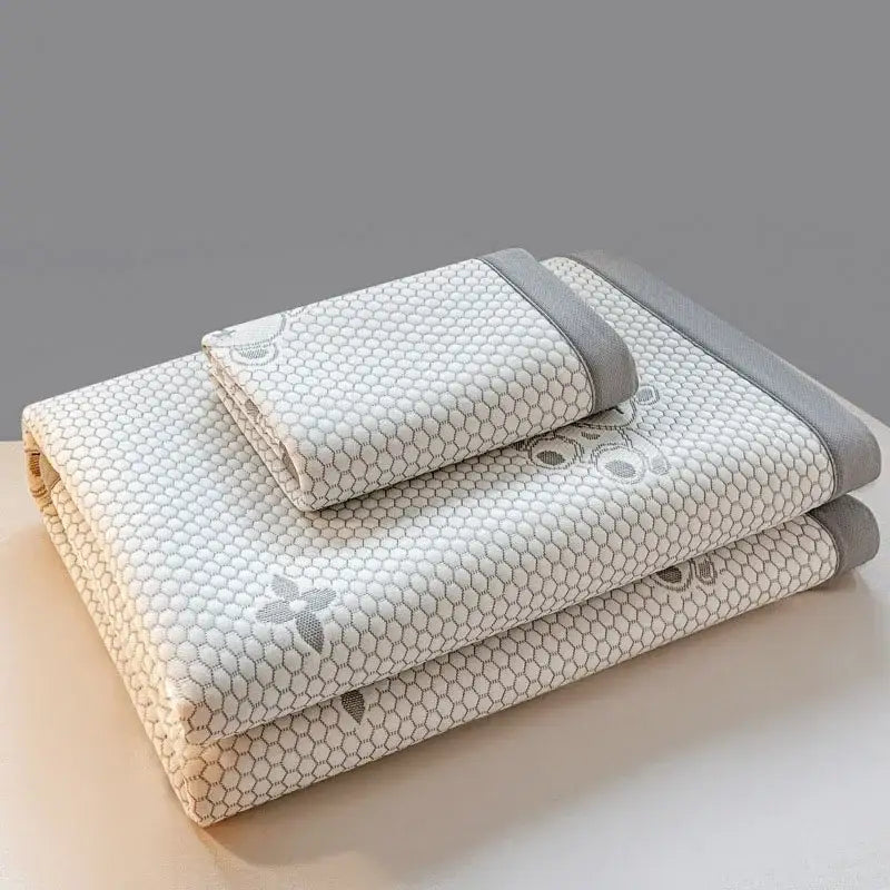 A set of three light gray and white honeycomb-patterned embroidered cooling feel mats in a bear white and pink mat set