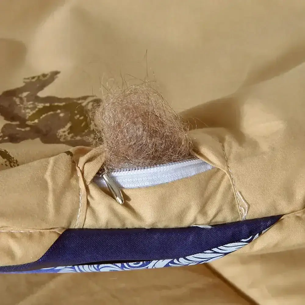 A tuft of light brown camel hair protrudes from the zipper opening of a beige decorbites camel hair quilted blanket