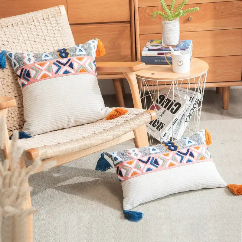 Embroidered blue tufted pillow cover with geometric embroidery in pink blue and orange hues and colorful tassels