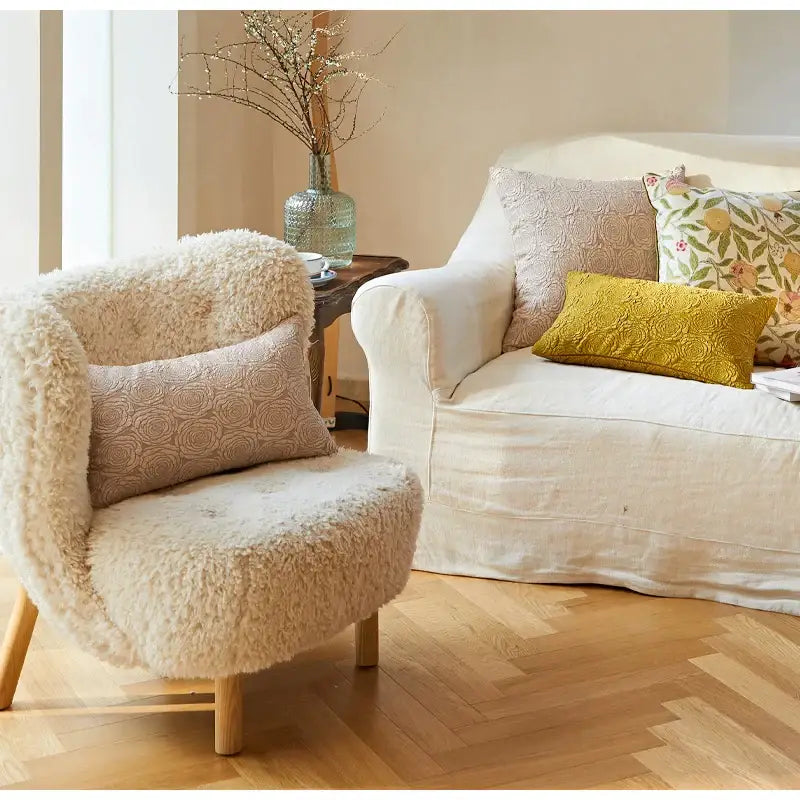 Cream-colored sheepskin armchair with wooden legs featuring decorbites citron flowers embroidered pillow case decor