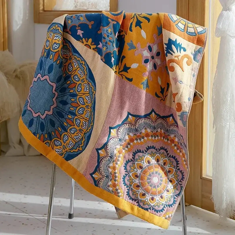 A vibrant patchwork bath towel with intricate mandala patterns in blue yellow pink and orange made of soft cotton gauze bath towels decorbites cotton gauze