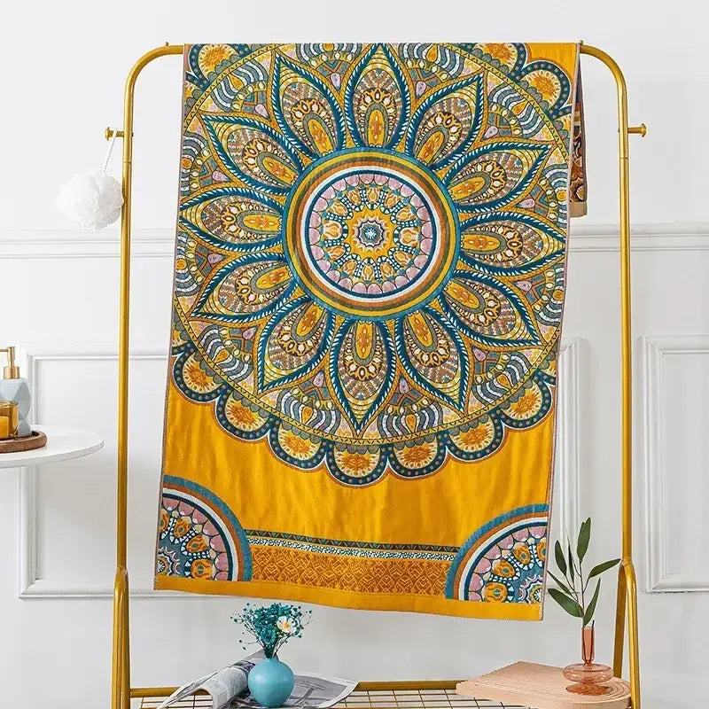 Vibrant yellow mandala tapestry with intricate teal gold and pink patterns hanging on a golden rack decorbites cotton gauze bath towels bathroom decor