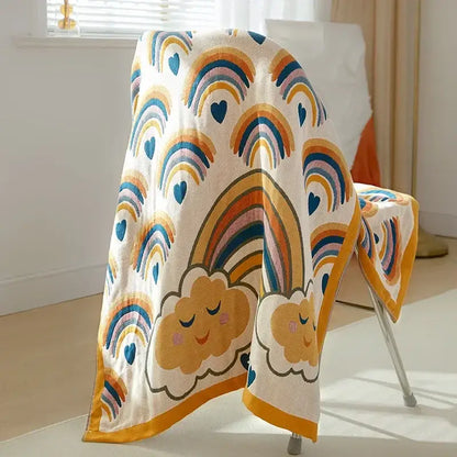 Cozy cream-colored cotton gauze bath towel with colorful rainbows and smiling clouds embroidered for bathroom decor