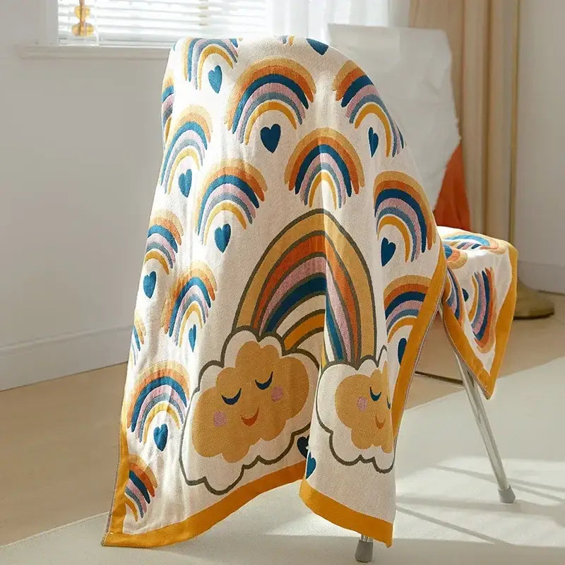 Cozy cream-colored cotton gauze bath towel with colorful rainbows and smiling clouds embroidered for bathroom decor