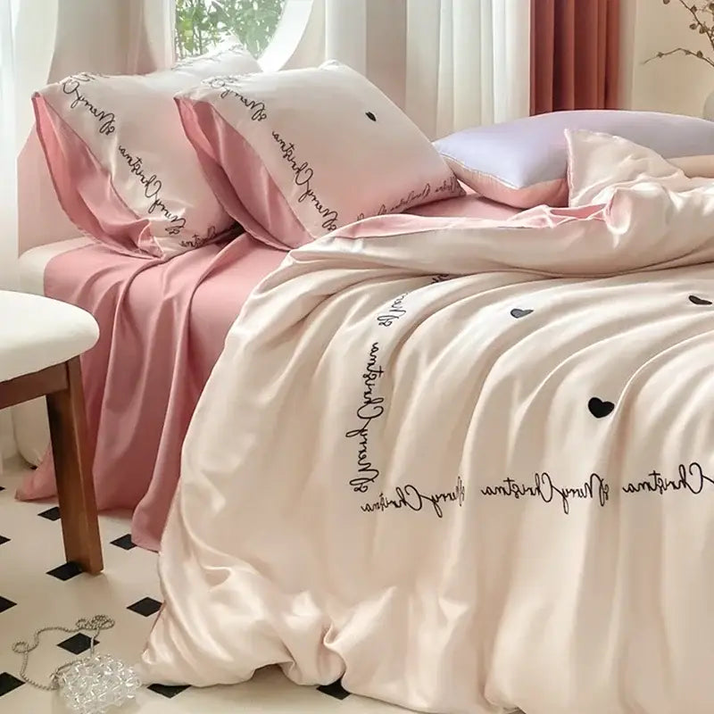 Pink satin duvet cover set with black cursive script and heart embroidery from decorbites ice silk bedding sets collection