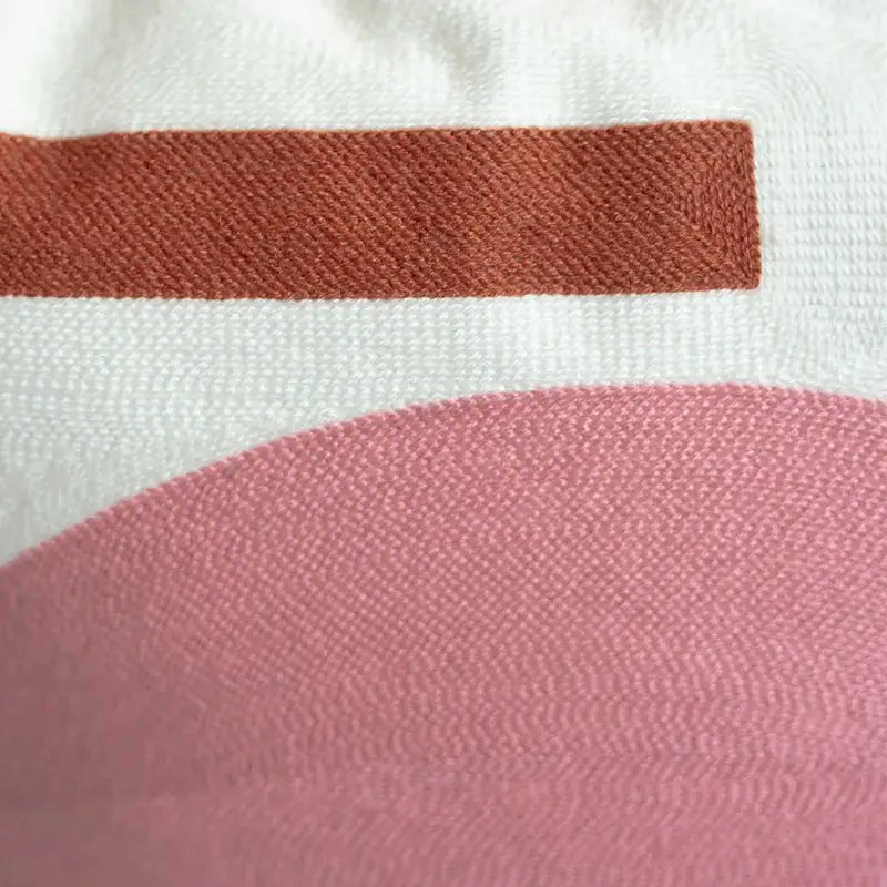 Embroidered cushion cover set featuring soft white fabric with rust stripe and curved pink section for living room decor