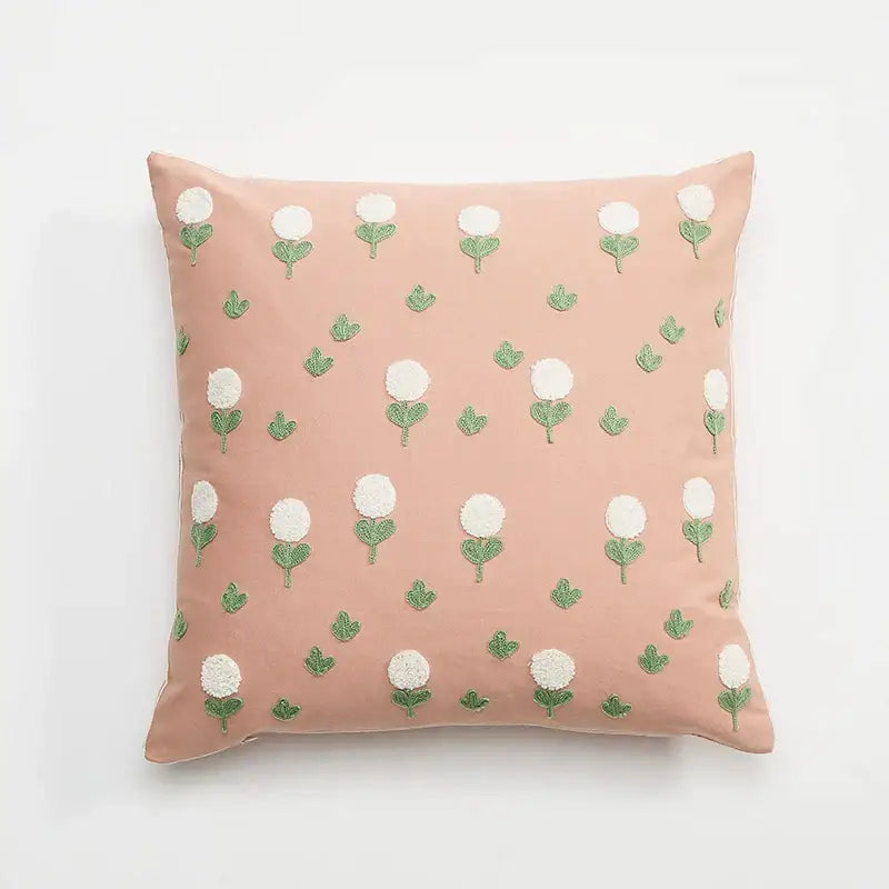 A soft pink cushion cover featuring embroidered daisy dandelion flowers and green leaves for white living room decor