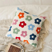 A cozy white cushion cover with embroidered daisy dandelion flowers in vibrant colors for living room decor
