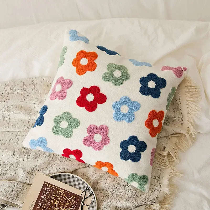 A cozy white cushion cover with embroidered daisy dandelion flowers in vibrant colors for living room decor