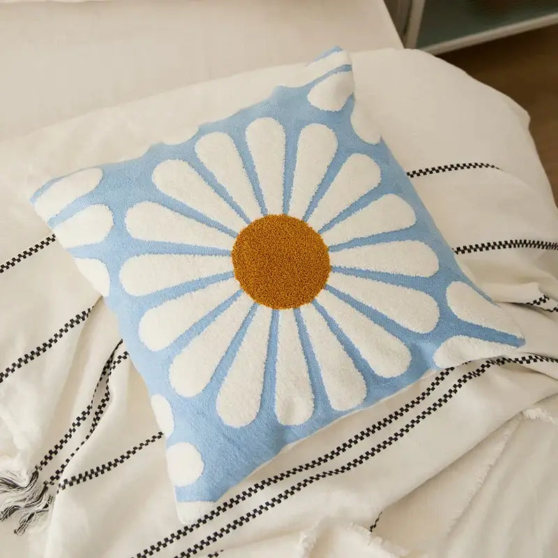 A soft light blue cushion cover featuring an embroidered daisy dandelion design with a textured golden center for living room decor
