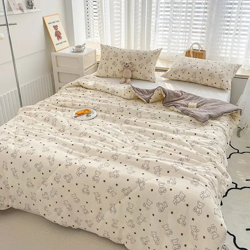 Cream-colored quilted double gauze comforter with black-outlined teddy bears and stars featuring rabbit print design