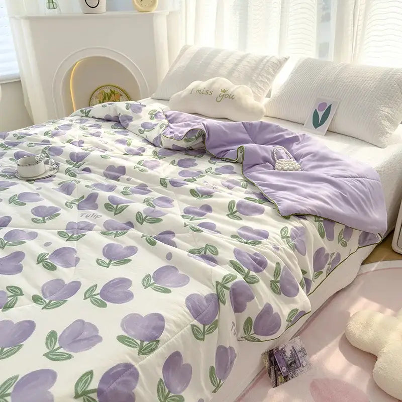 A soft white double gauze rabbit print quilted comforter with embroidered purple tulips and green stems for bedrooms