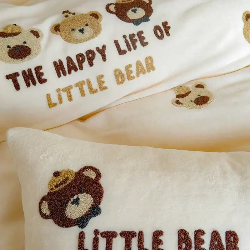 Cream plush pillow with embroidered teddy bear faces and text in embroidered fleece winter bedding set design