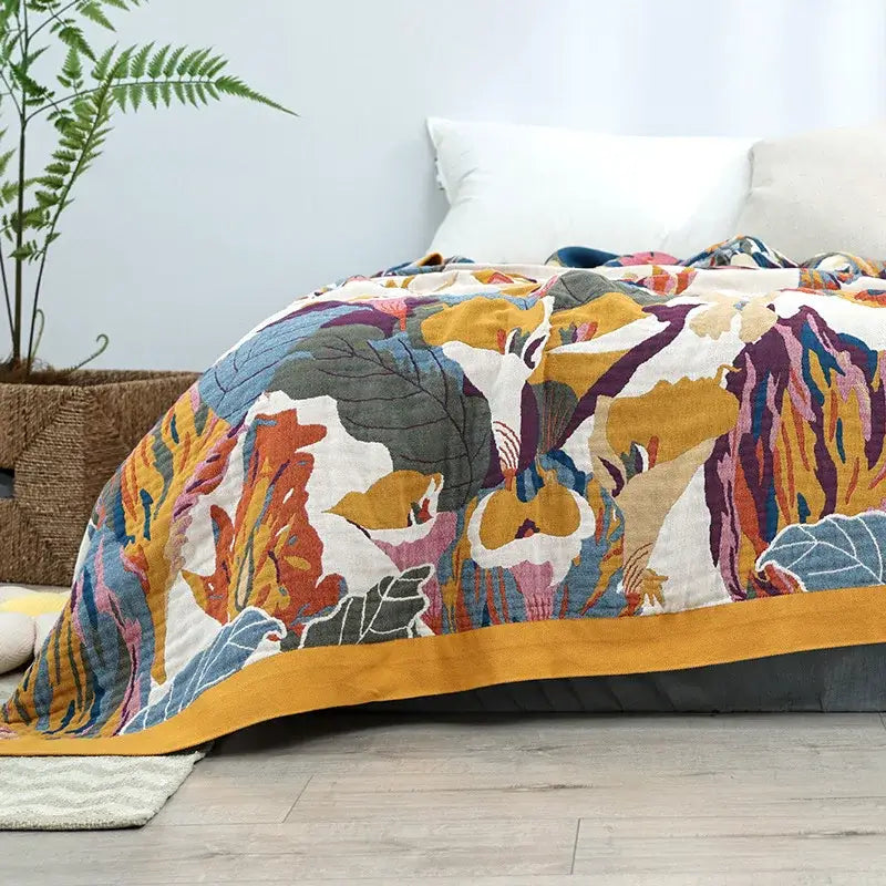 Vibrant hand-quilted decorbites cotton gauze throw blanket with mustard yellow, purple, and teal botanical print