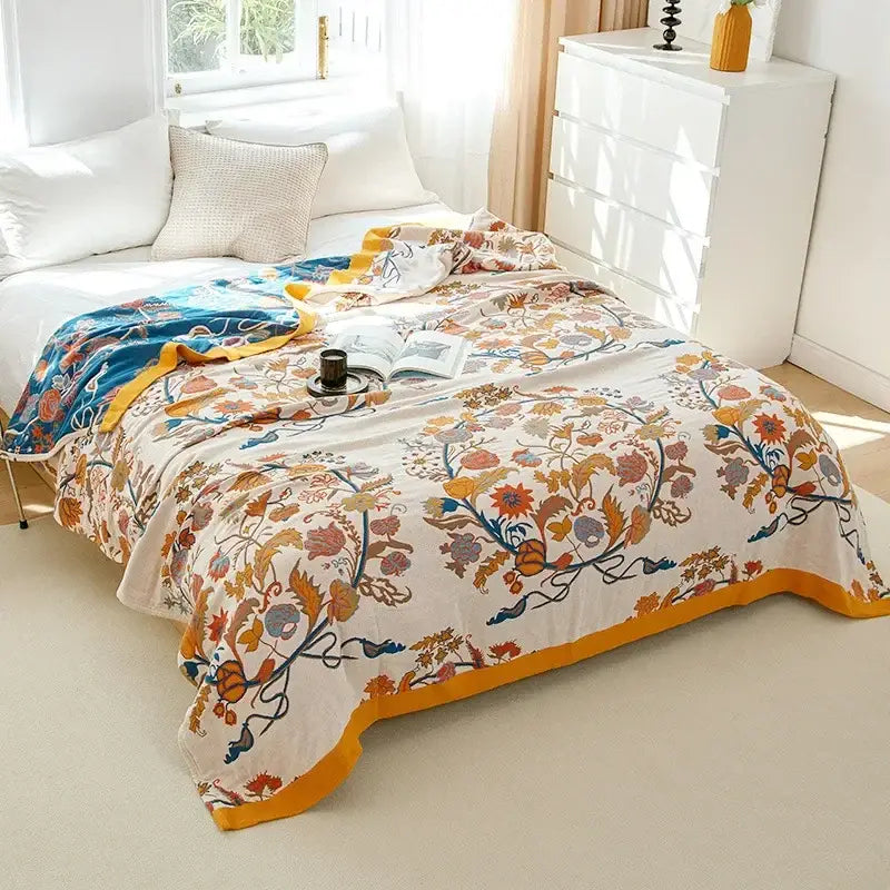 A cream decorbites cotton gauze bedroom blanket with vibrant orange blue floral pattern and embroidered border