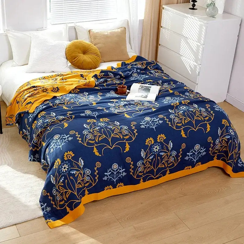Embroidered floral blue and cream decorbites cotton gauze bedroom blanket with a cozy blue and gold fleece surface