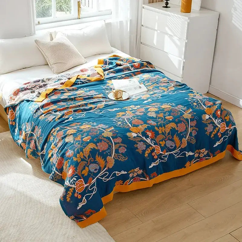 Vibrant blue embroidered floral bedroom blanket with mustard-yellow border made from decorbites cotton gauze fabric