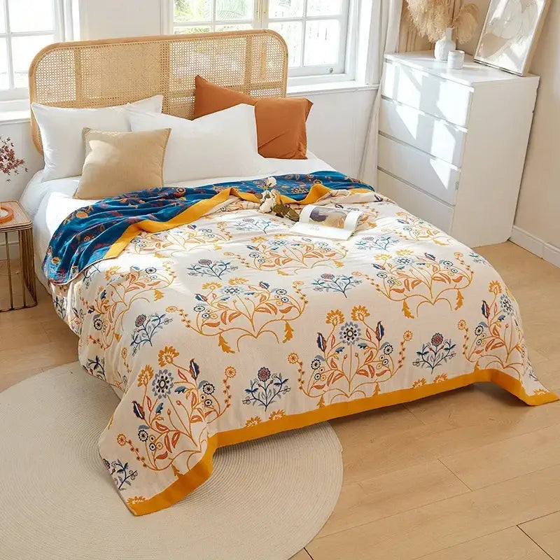 A cozy cream-colored cotton gauze bedroom blanket with vibrant floral pattern and embroidered mustard border by decorbites cotton gauze