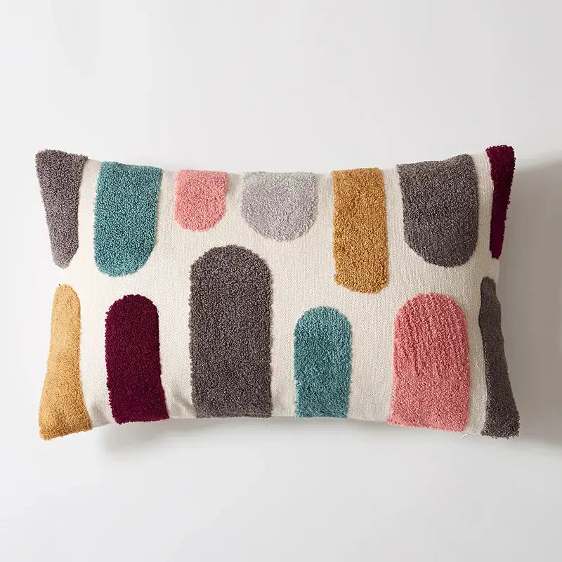 Cream-colored rectangular pillow cover with embroidered floral dot texture in muted teal, rose, mustard, gray, and burgundy for home decor