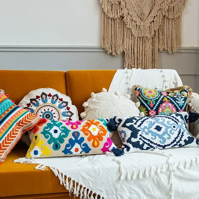Vibrant embroidered flower boho long cushion covers with geometric and floral patterns on mustard-yellow sofa