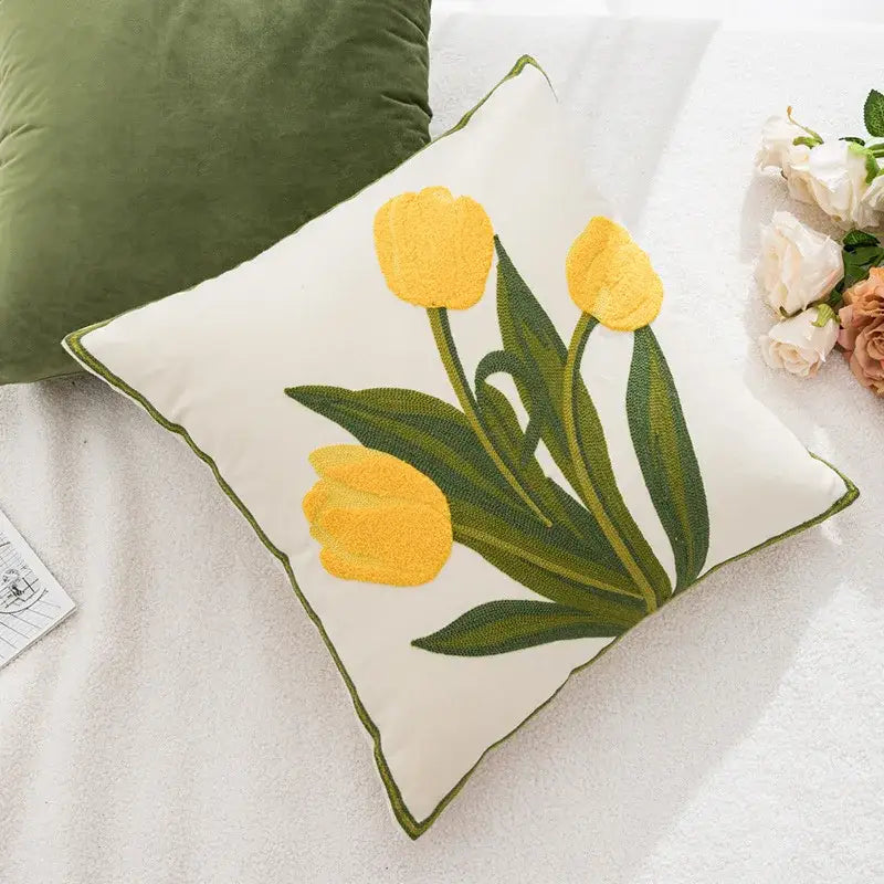Cream-colored pillowcase cover with embroidered yellow tulips green leaves and matching olive-green stitched border