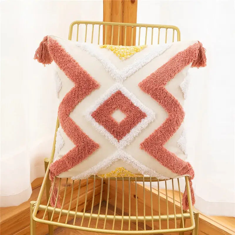Cozy cream pillow cover with embroidered geometric leaves pattern in coral and yellow and tasseled corners for living room decor