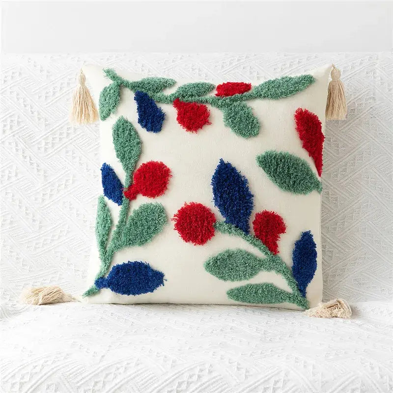 Cream-colored pillow cover with embroidered geometric leaves in red and blue and beige tassels for living room decor