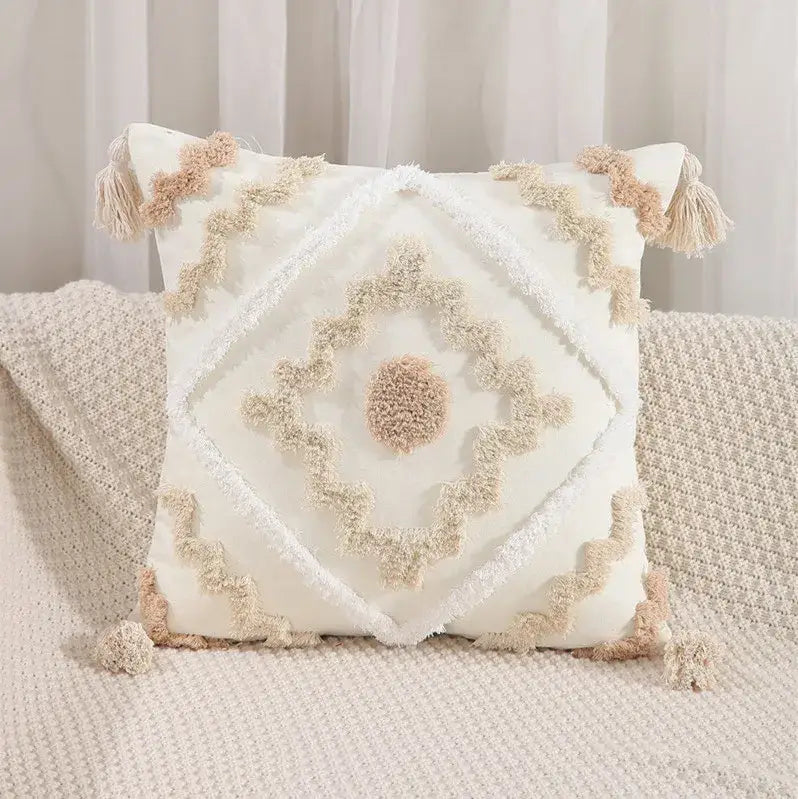 Cream-colored pillow cover with embroidered geometric leaves design and tasseled textured detailing for living room decor