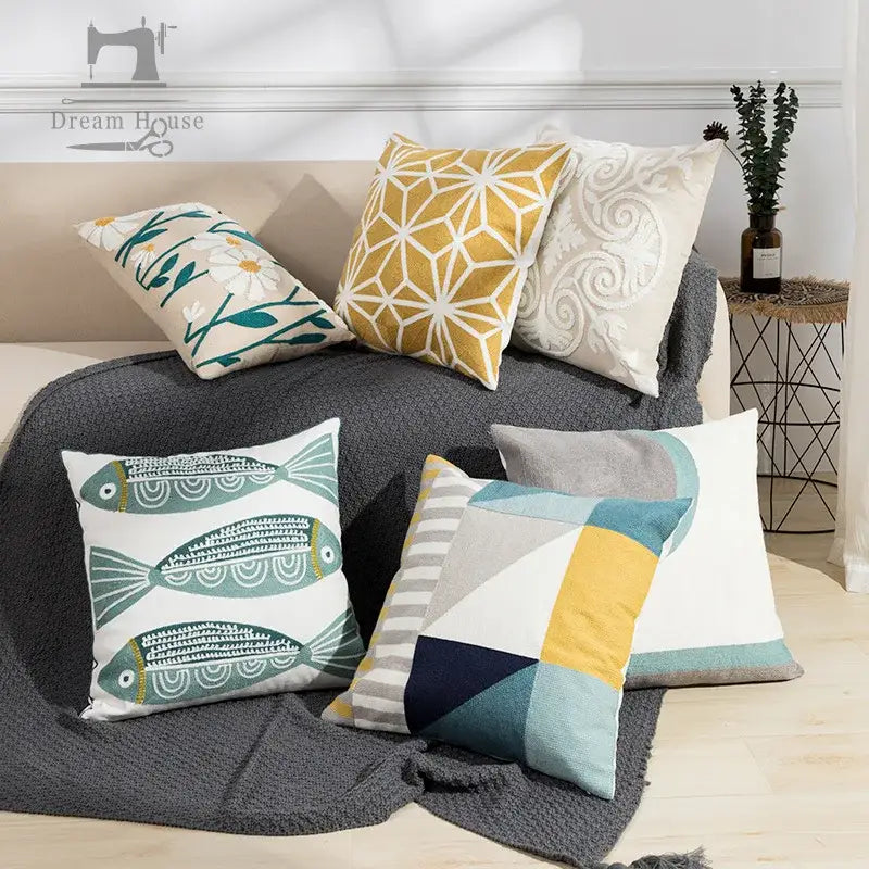 Set of six decorative pillow covers with embroidered green and gold fish and daisy yellow floral geometric patterns