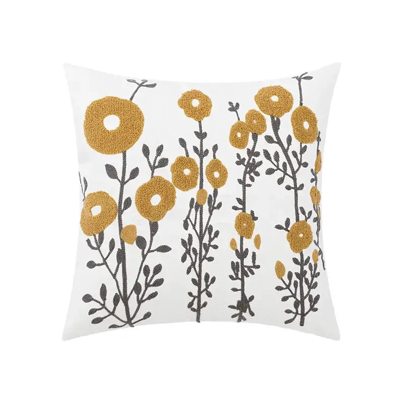 White throw pillow cover with embroidered daisy yellow floral and black stems featuring a tufted design