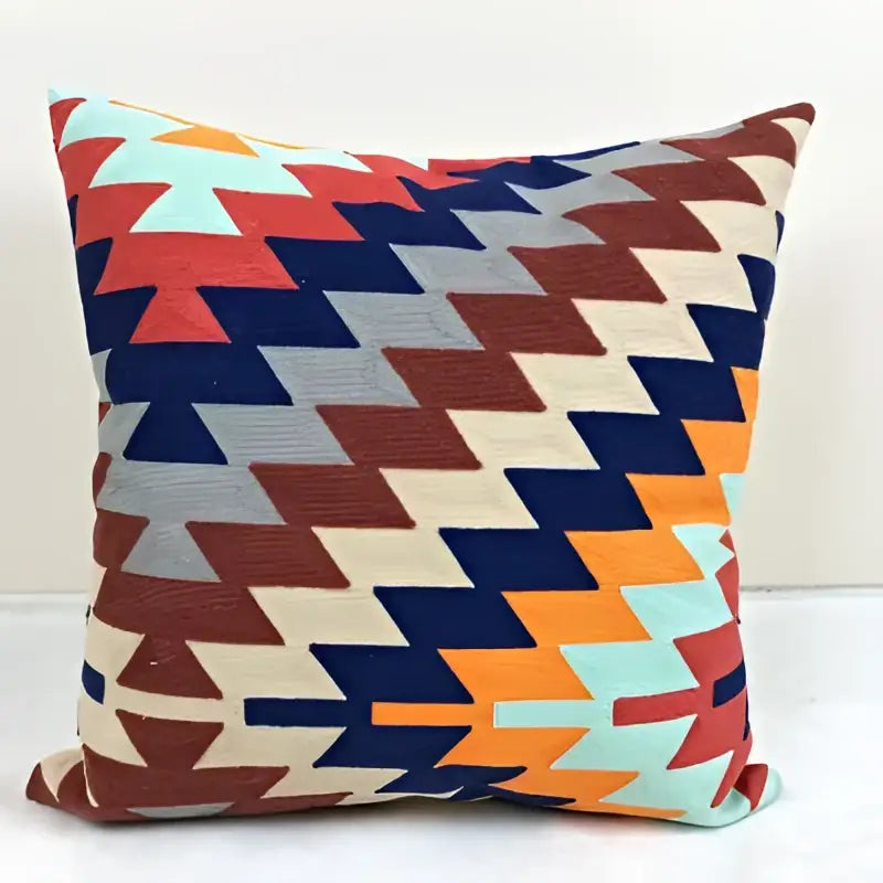 Vibrant embroidered kilim style cushion cover with bold red navy blue orange and cream geometric pattern in woven textile finish