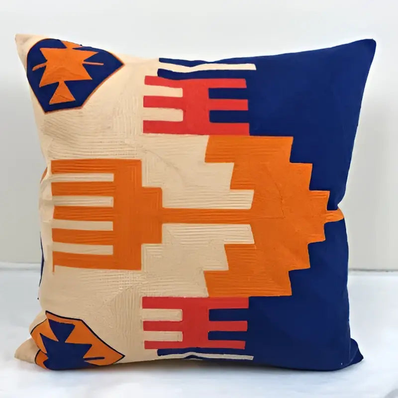 Square embroidered kilim style cushion cover with bold orange red navy geometric patterns on beige for living room
