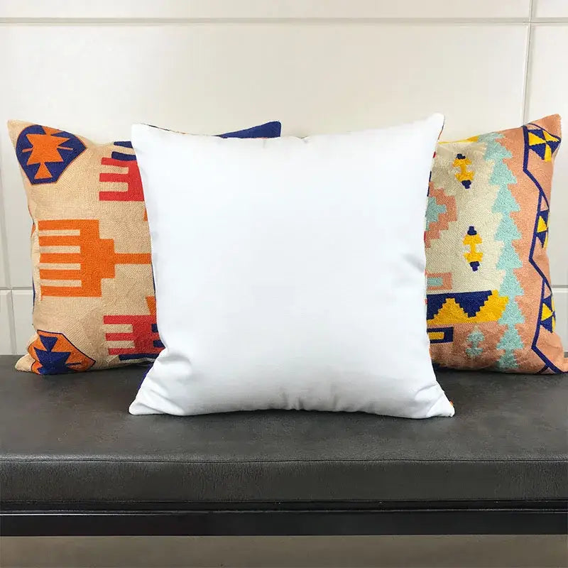 White square cushion cover with smooth solid fabric surface featuring embroidered kilim style geometric design