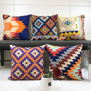 Vibrant embroidered kilim style cushion cover with geometric pattern in bold orange purple blue and red colors for living room
