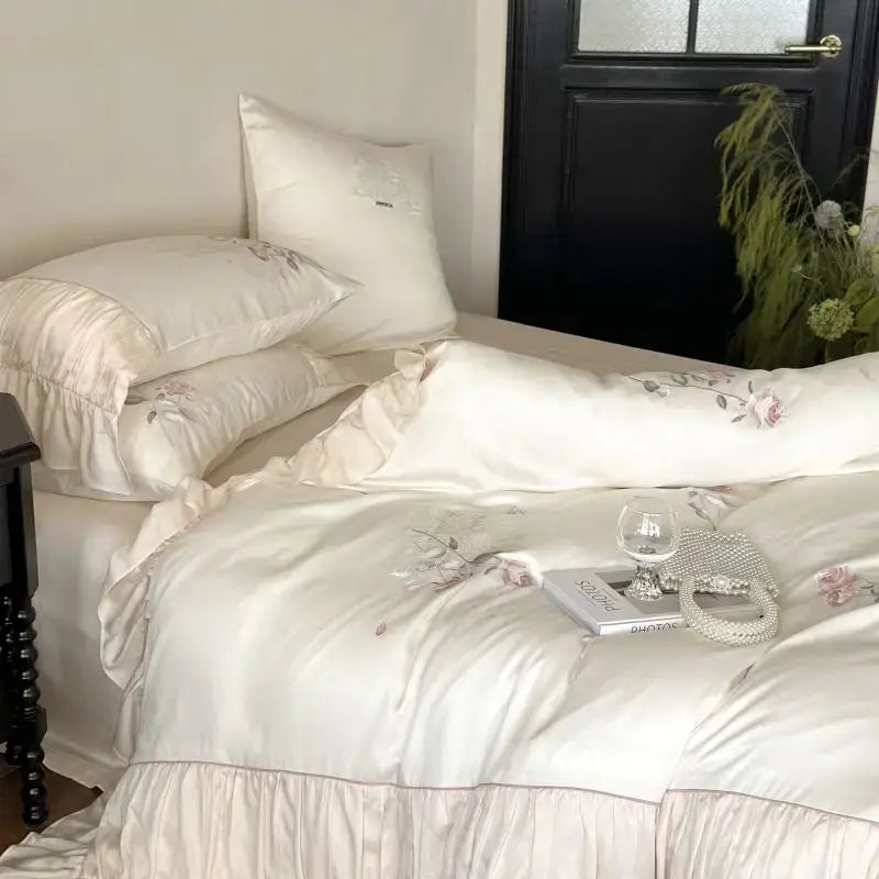 Cream-colored satin bedding set with delicate pink floral embroidery and ruffled edges for lace princess bedding decor