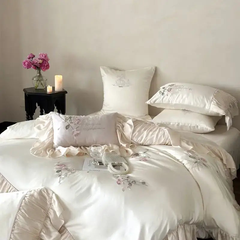 Cream-colored satin bedding set featuring delicate floral embroidery and ruffled edges in embroidered lace princess style