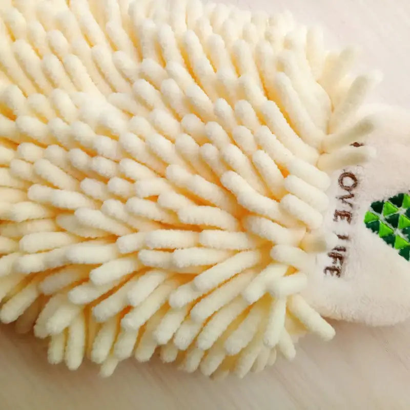Cream-colored plush scrubbing mitt with soft bristles and green logo paired with embroidered microfiber hand towel pale green and cream