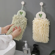 Two embroidered microfiber hand towels in pale green and cream hang with heart tops and i love life text for kitchen decor