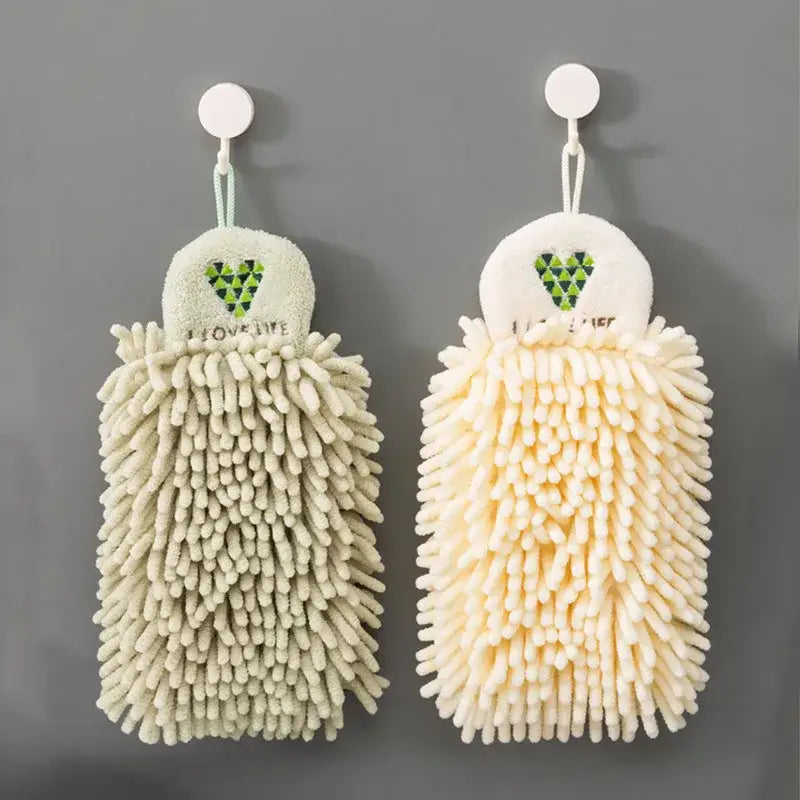 Two hanging embroidered microfiber hand towels in pale green and cream with a green heart design for kitchen decor