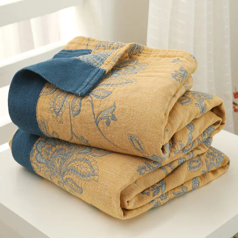 Stacked embroidered mustard and navy cotton gauze summer quilts with paisley embroidery and fabric borders from decorbites cotton gauze