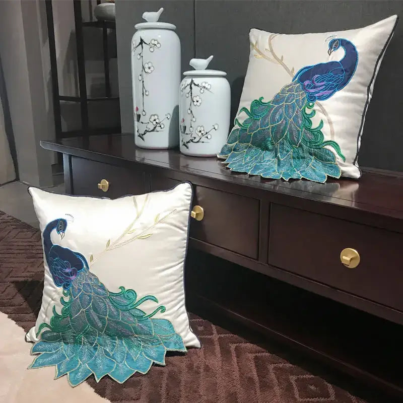 Cream satin cushion cover with embroidered peacock design in blue and teal for living room decor