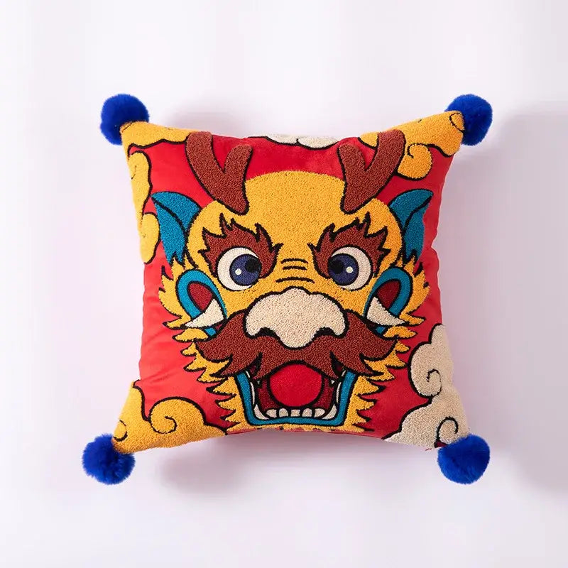 Vibrant red cushion cover with detailed embroidered chinese dragon and four bright blue pom-poms for decorbites dragon year decor