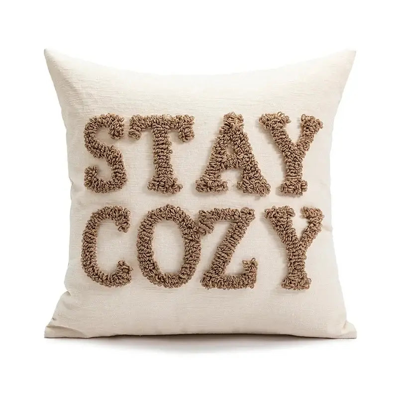 Cream-colored throw pillow with stay cozy embroidered in beige yarn as part of decorbites cartoon christmas pillow covers