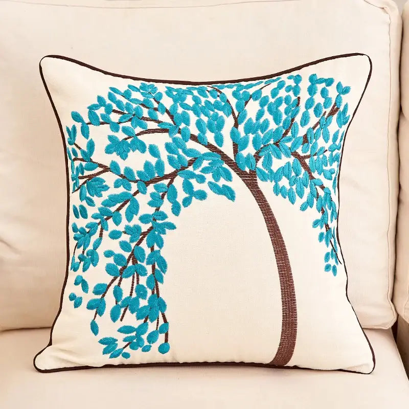Cream-colored embroidered cushion cover with turquoise tree design and dark brown border for living room sofa